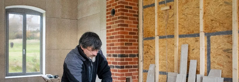 Eine Person steht in einem Raum mit Wandverkleidung.
